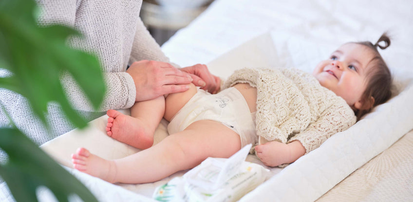 Woman changing baby with diaper rash