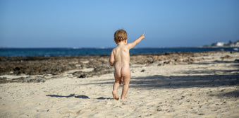 Naked baby running on the beach