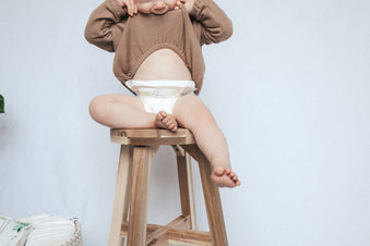 Baby in bamboo diaper sitting on stool